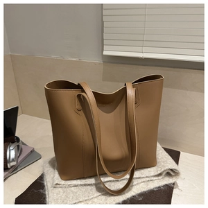 Detailed macro shot of the spacious camel leather tote interior with gold fashion logo