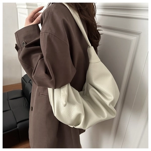 Détail du grand sac hobo crème en cuir souple plissé avec bandoulière minimaliste