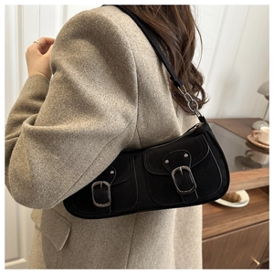Détail du sac baguette noir vintage avec deux poches avant et boucle en métal argenté