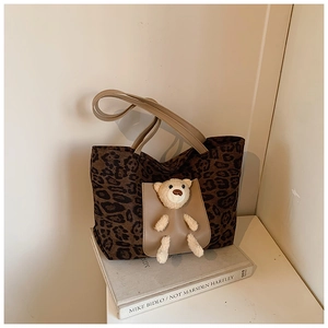 Close-up of leopard print tote bag with brown card pocket and plush bear charm decoration