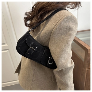 Detailed view of the double-pocket design and silver buckles on a black vintage baguette bag