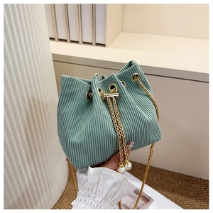 Détail du sac seau en velours côtelé vert clair avec perles et chaîne dorée