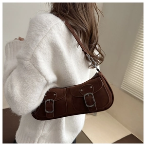 Detail of vintage dark brown suede underarm bag with double pockets and metal chain strap
