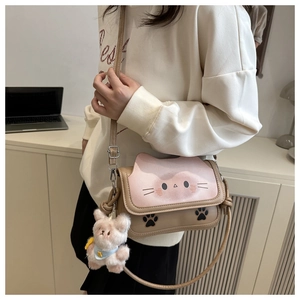 Detail of beige cat-shaped shoulder bag with pink flap and cute plush bear charm