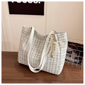 Détail du sac cabas en tweed blanc avec nœud en perles et texture de fils métalliques