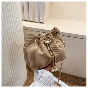 Détail du sac seau en velours côtelé kaki avec chaîne dorée et breloques en perles