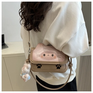 Detail of cute cat-themed pink handbag with plush charm and cat ear silhouette