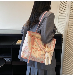 Détail du sac cabas en toile avec imprimés graffitis rouges et breloque lapin