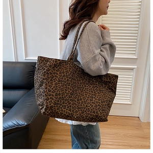 Detailed view of the large capacity leopard print tote bag on a model shoulder