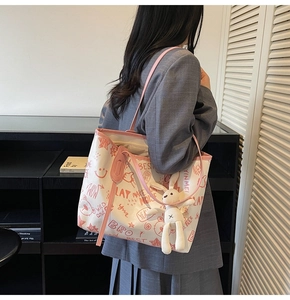Détail du sac fourre-tout blanc avec graffitis rouges et porte-clé lapin en peluche