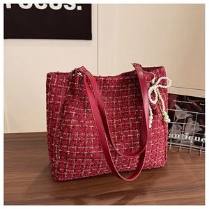 Détail du sac cabas en tweed rouge avec poignées en cuir et breloque nœud en perles
