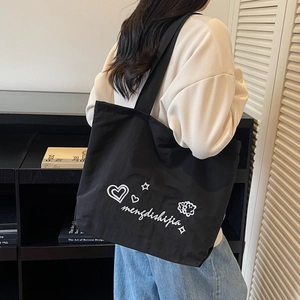 Fashionable black canvas tote bag with heart and star prints for daily casual use