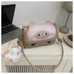 Detail of khaki crossbody bag with pink cat ear flap and cute plush bear charm