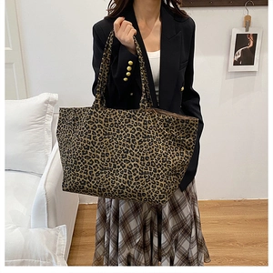 Chic leopard print tote bag styled with a professional suit in a cozy indoor setting