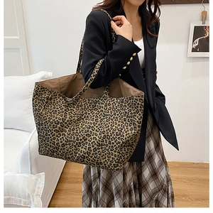 Detail of a large leopard print canvas tote bag styled with a professional autumn outfit