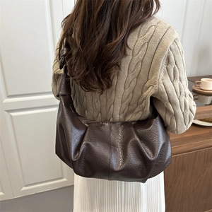 Women's dark brown half-moon crossbody bag with elegant ruched detail and knot strap