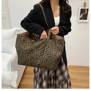 Detailed view of a large leopard print canvas tote bag styled with a professional outfit