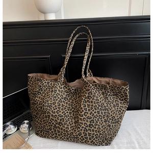 Close-up of leopard print tote bag with laptop and books in a modern indoor setting