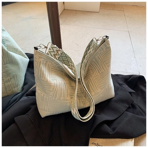 Dettaglio della borsa tote intrecciata verde menta con tracolla larga a motivi geometrici