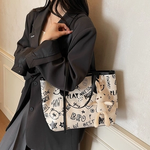 Sac fourre-tout en toile graffiti avec lapin en peluche porté à l'épaule