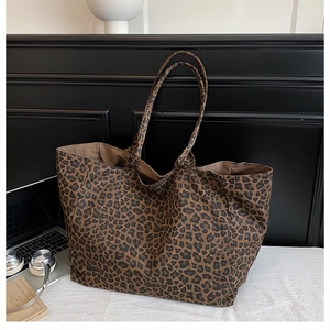 Macro detail of large leopard print tote bag with long handles and spacious interior
