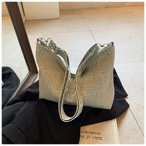 Dettaglio borsa tote in tessuto verde menta con tracolla geometrica larga e design