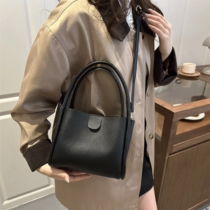 Minimalistische schwarze matte Tragetasche mit Griffen und Schultergurt in Lifestyle-Szene
