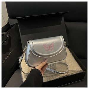 Detailansicht der silbernen Metallic-Tasche mit rosa Schmetterlings-Stickerei