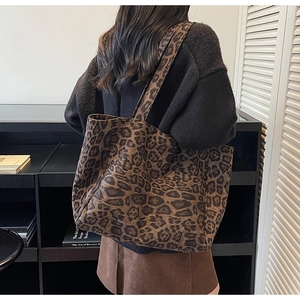 Détail d'un grand sac fourre-tout à motif léopard avec bandoulière porté par un modèle
