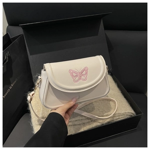 Detail der cremefarbenen Tasche mit Schmetterlingsstickerei in schwarzer Geschenkbox
