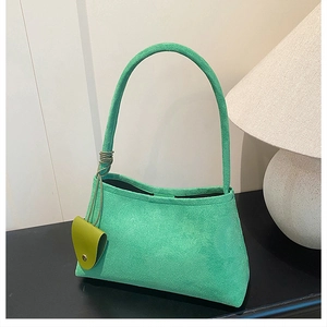 Vue détaillée du sac à bandoulière en daim vert mat avec petit charme assorti