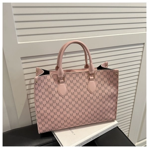 Detail of light pink tote bag with M letter print on white book and window background