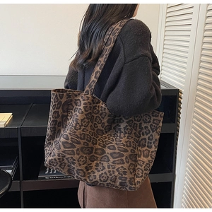 Gros plan d'un grand sac cabas léopard avec larges anses dans un décor quotidien