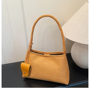 Détail du sac à bandoulière en feutre jaune moutarde avec nœud et mini pendentif