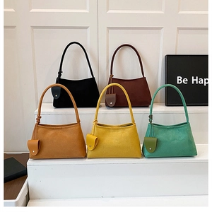 Détail de cinq sacs croissants en daim de couleurs variées avec mini pochette assortie