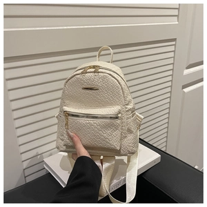 Détail de la texture tressée et de la poche zippée sur ce sac à dos en similicuir crème