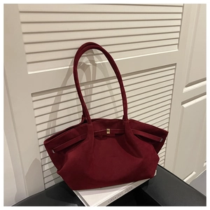 Detail of burgundy suede tote bag featuring soft texture and elegant gold buckle closure