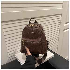 Détail d'un mini sac à dos marron foncé avec texture tressée et fermeture dorée chic