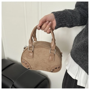 Detail of khaki suede mini Boston bag with retro metal rivets and sturdy handles