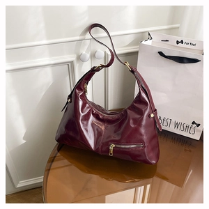 Detail der burgunderroten Hobo-Tasche aus Lackleder mit verstellbarem Schnallenriemen