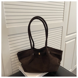 Detail of dark brown suede tote bag featuring a minimalist design and gold metal buckle