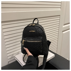 Vue détaillée du mini sac à dos noir avec texture tissée et détails de fermeture dorés
