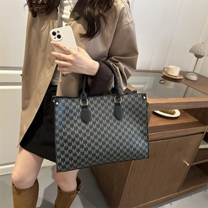 Luxe letter pattern tote bag with leather handles in a chic autumn fashion setting