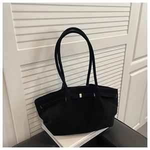 Close-up of black matte tote bag with elegant gold buckle and sleek leather texture
