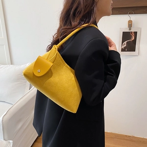 Sac à bandoulière en feutre jaune pour femme porté avec un blazer noir chic