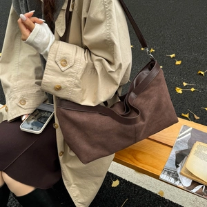 Vintage brown suede tote bag with leather trim on model for autumn streetwear fashion