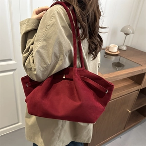 Large dark red faux suede tote bag for women with slim straps in a casual lifestyle setting
