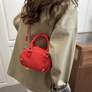 Chic red faux suede crescent crossbody bag with silver rivet details and strap