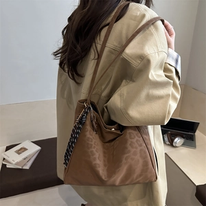 Large brown leopard print tote bag with stylish scarf charm on a shoulder strap