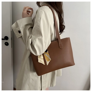 Brown matte tote bag with geometric silk scarf detail shown on a model's shoulder
